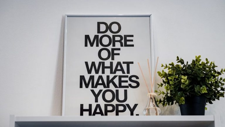 Framed quote 'Do More of What Makes You Happy' with plant and aroma diffuser.